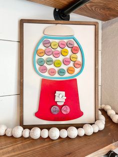 a gumball machine is hanging on the wall next to some beads and other items