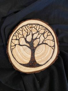 a tree is carved into a piece of wood on a black cloth with the image of a tree in it