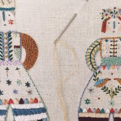 two embroidered dolls sitting next to each other