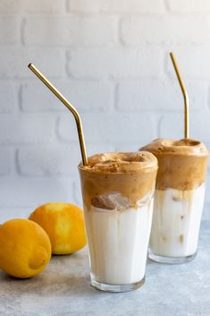 two glasses filled with ice cream next to lemons