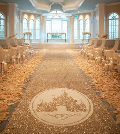 the aisle is decorated with white chairs and lit candles in front of large chandeliers