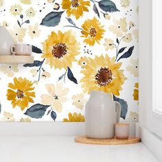 a white vase sitting on top of a counter next to a yellow flower wallpaper