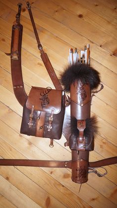 two leather bags with fur on them sitting on a wooden floor next to each other