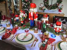 a table set for christmas dinner with nutcrackers