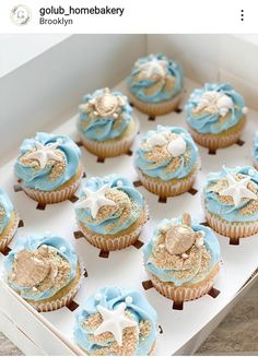 a box filled with blue and gold cupcakes