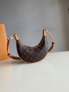 Description L.V Loop Monogram Canvas For Women, Shoulder And Crossbody Bags 9.1in/23cm LV M81098 Rep 1:1 Created by Nicolas Ghesquière for the Cruise 2022 Collection, the Loop handbag is a half-moon baguette, inspired by the Croissant bag from the House archives. It has a body-friendly, compact shape and a chain for shoulder carry, as well as a cross-body strap. The front zip pocket closes with an LV Circle zip pull. Size: 9.1 x 5.1 x 2.4 inches / 23 x 13 x 6 cm (Length x height x width) Monogra Croissant Bag, Lady Bags, Evening Clutch Bag, The Loop, Half Moon, Monogram Canvas, Evening Bags, Backpack Bags, Mini Bag