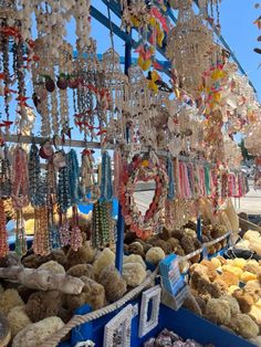 an outdoor market with lots of beads and necklaces hanging from it's ceiling