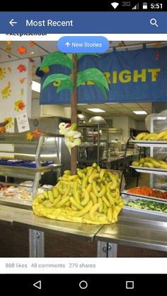 bananas and other fruits are on display in a store's food section, with the bright sign above them