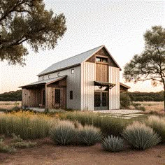 a small white house sitting in the middle of a field