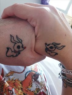 two people with matching tattoos on their hands