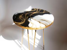 a black and white marble topped table with gold legs