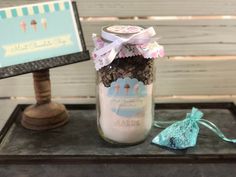 a glass jar filled with lots of chocolate and marshmallows sitting on top of a table