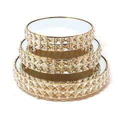 three gold - plated dishes with clear glass plates stacked on top of each other