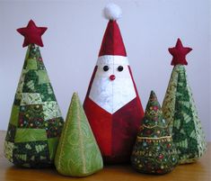 three small christmas trees with santa clause on them