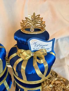 two blue boxes with gold ribbons and crowns on them