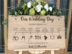 a wooden sign with flowers and wedding rings on it that says our wedding day,