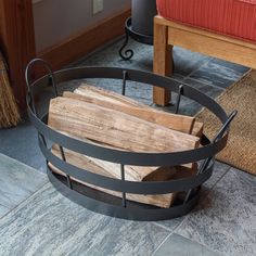 a firewood log is in a metal basket on the floor