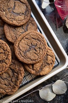 chocolate cookies cooling on a wire rack in front of some leaves and other decorations,