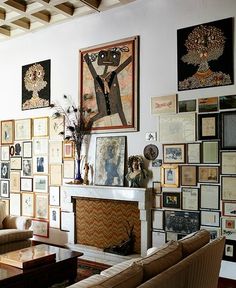 a living room filled with furniture and pictures on the wall next to a fire place