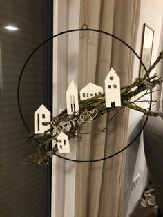 a glass vase filled with white houses on top of a table