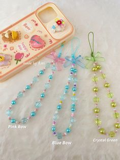 three beaded necklaces and a cell phone case on a white furnishing