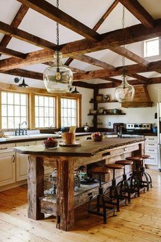 a kitchen with wooden beams and an island in the middle, surrounded by stools