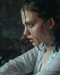 a woman with wet hair sitting in front of a laptop computer and looking at the screen