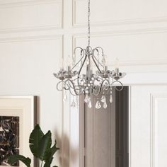 a chandelier hanging from the ceiling in a room with white walls and flooring