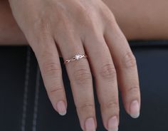 a woman's hand with a gold ring on top of her left hand, and a diamond in the middle