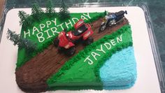 a birthday cake with cars and trees on it