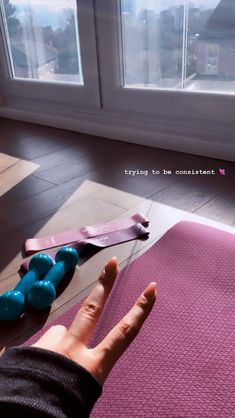 a person's hand on top of a yoga mat