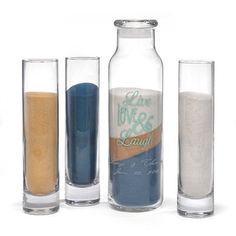 three glass bottles with sand in them next to each other