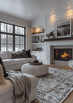 a living room filled with furniture and a fire place in front of a large window