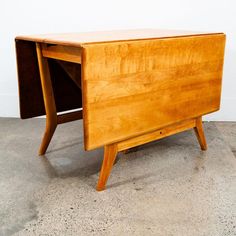 a wooden desk sitting on top of a cement floor