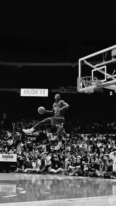 a black and white photo of a basketball player dunking the ball