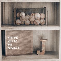 two shelves filled with baseballs and a letter j