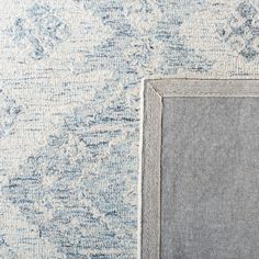 a blue and white rug with a square frame on the bottom right corner, in front of it