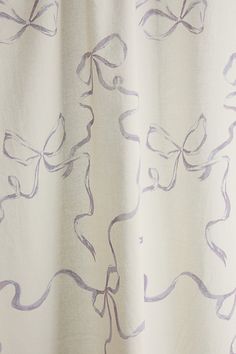 a white curtain with purple designs on it