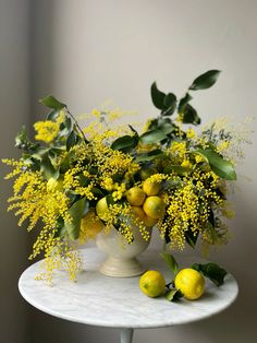 a white table topped with yellow flowers and lemons