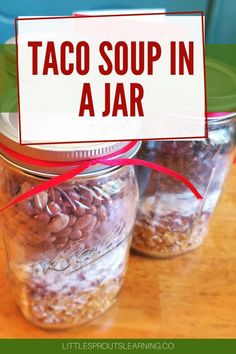 three jars filled with taco soup in a jar on top of a wooden table