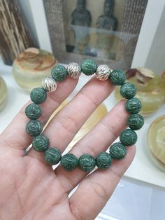 Gift idea 🎁! Deep green Jade beads, 10.5 mm size, engraved with Ruyi swirls to invite  good fortune; Fei Cui, Type A natural Jadeite (non-bleached, non-dyed, non-treated materials) of glossy deep green color, each finely detailed. This Ruyi Bracelet is charmed with 3 pieces of beautifully chiselled Sterling Silver Beads, 10.5 mm size. Bracelet size 17 cm, weighs 36 grams (more or less); may be upsized (to 18 cm) or downsized upon request. To request for resize, you may send us a direct message Adjustable Carved Bracelets With Round Beads, Green Carved Bracelet As A Gift, Green Carved Bracelets As Gift, Green Carved Bracelet For Gift, Spiritual Carved Round Beads Bracelets, Spiritual Carved Round Beads Bracelet, Green Stretch Bracelet With Polished Round Beads, Green Stretch Bracelet With Polished Beads, Green Spiritual Bracelets With Large Beads