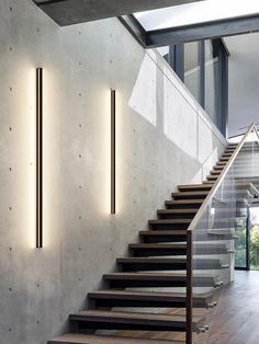 the stairs are lined up against the concrete wall and light is shining down on them