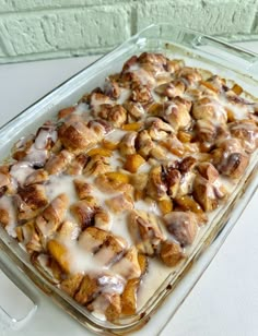 a casserole dish with cinnamon rolls and icing