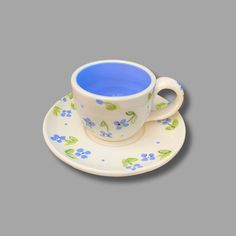 a cup and saucer with blue flowers on it