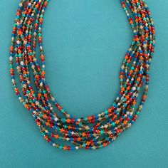 Multi Strand Necklace (10 Strands) Hand Strung Using Premium Seed Beads. Red, Blue, Orange, Pearl, Tan. Lobster Claw Clasp, 2” Extender. Stainless Steel Beadcaps Finish The Ends Of The Strands. Multicolor Beaded Jewelry For Fiesta, Southwestern Multi-strand Beaded Necklace With Large Beads, Multicolor Large Beads Southwestern Jewelry, Southwestern Multicolor Beads For Jewelry Making, Southwestern Multi-strand Large Bead Necklaces, Southwestern Multi-strand Beaded Necklaces As Gift, Southwestern Multi-strand Necklaces With Large Beads, Southwestern Multi-strand Beaded Necklaces For Gifts, Southwestern Multi-strand Adjustable Beaded Necklaces