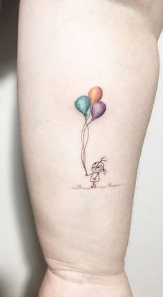 a small tattoo on the leg of a person with three balloons