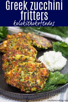 greek zucchini fritters with feta and herbs on a black plate