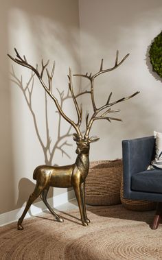 a golden deer statue sitting on top of a blue chair in a living room next to a wall