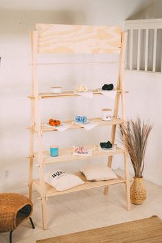 a wooden shelf sitting in the middle of a room next to a chair and rug