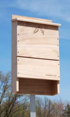 a wooden bird house sitting on top of a metal pole